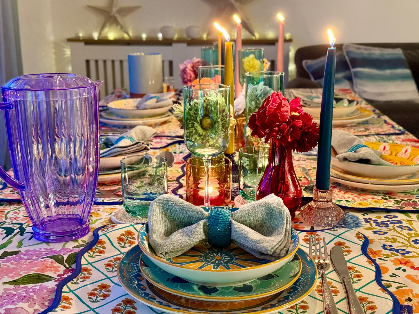 Richly styled dinner table with taper candles and colourful linens, perfect for hosting with a hired tablescape