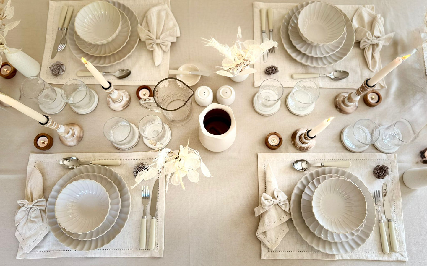 Top-down view of a neutral dinner table styled with coordinated rental tableware for elegant entertaining