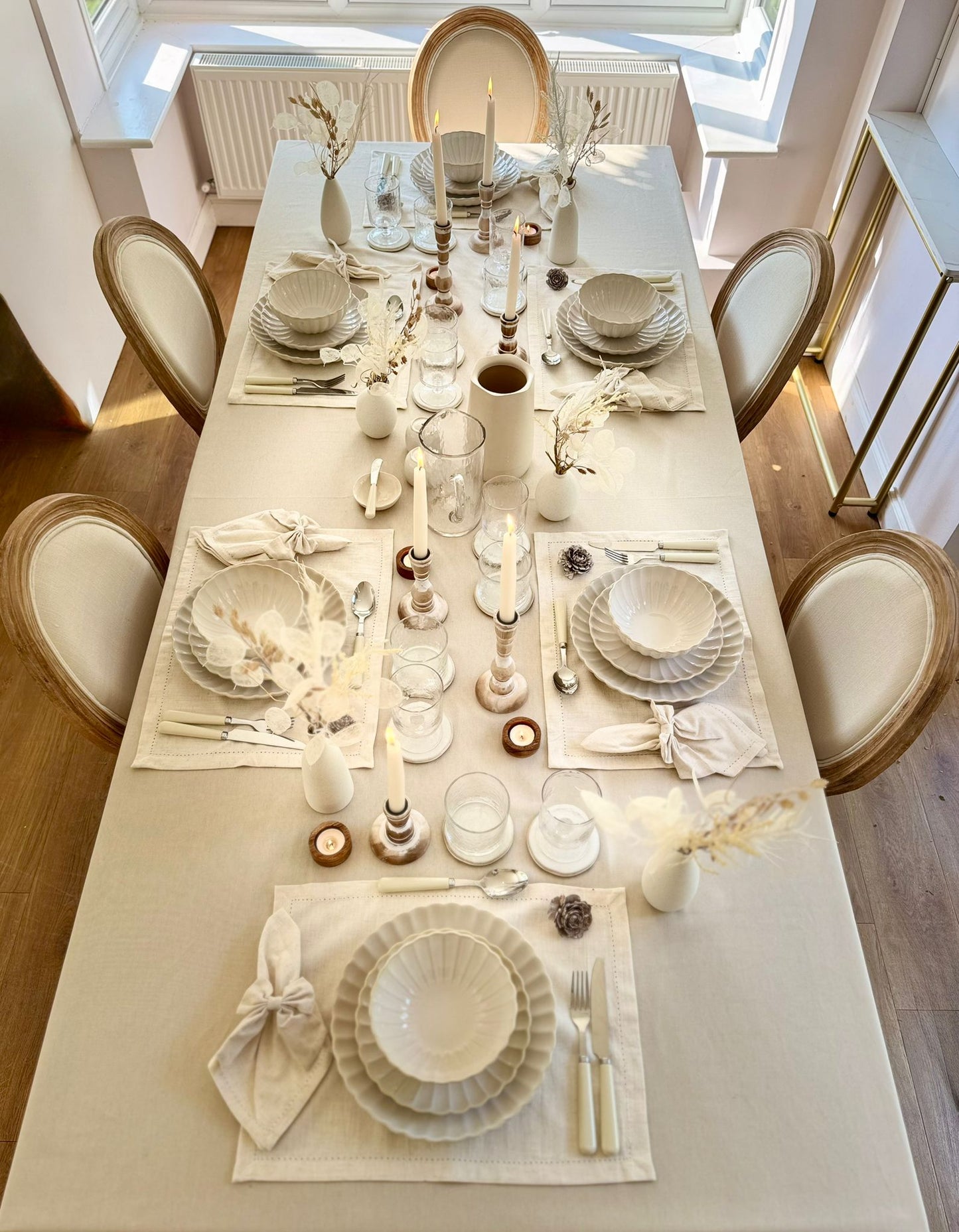 Top-down view of a neutral dinner table styled with coordinated rental tableware for elegant entertaining