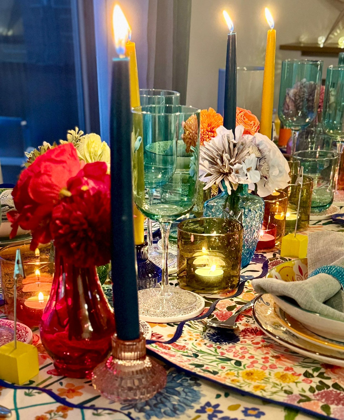 close up showing candle holders, bud vases, wine glasses, colourful table linens available to rent in the Vibrant Collection