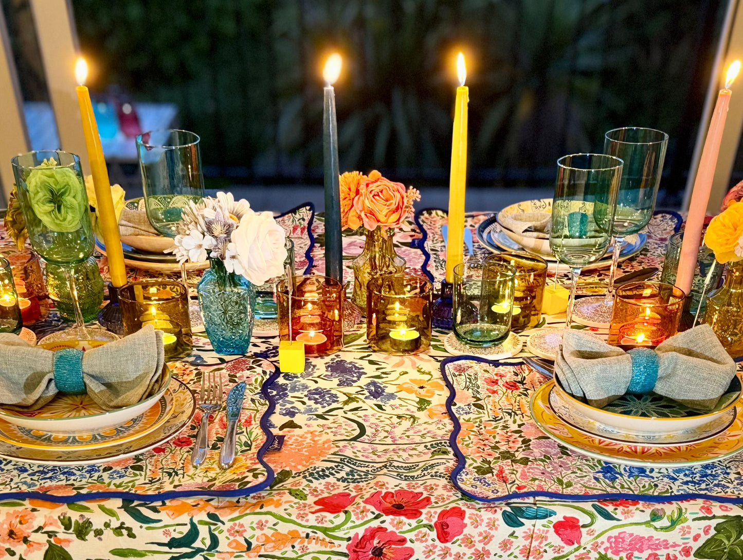 Richly styled dinner table with taper candles and colourful linens, perfect for hosting with a hired tablescape