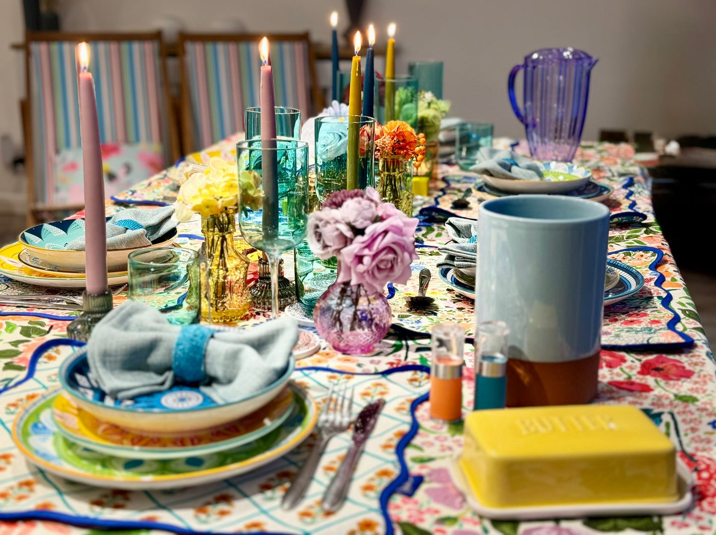 Vibrant ceramic plates with blue linen napkins, cutlery and accessories styled for a hired tablescape experience