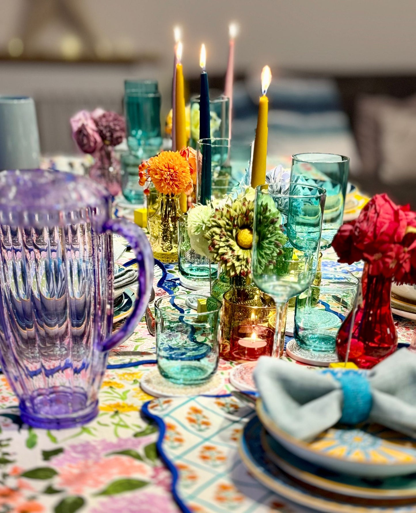 Richly styled dinner table with taper candles and colourful linens, perfect for hosting with a hired tablescape