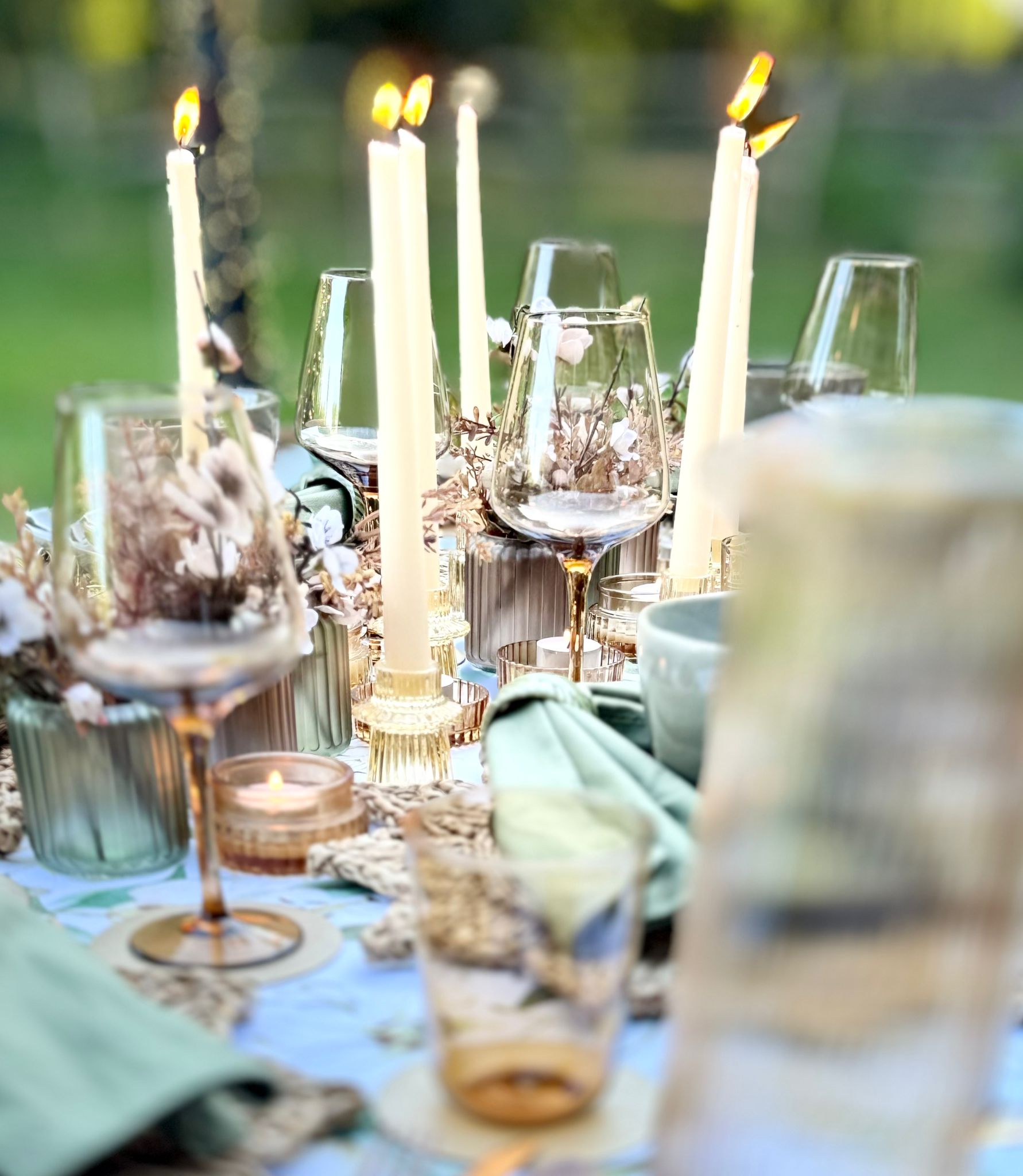 Warm taper candles and bud vases adding ambience to the neutral-toned dining table setup
